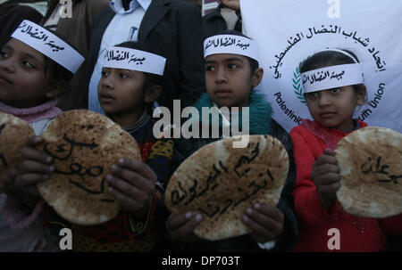 La bande de Gaza, Rafah, . 8 janvier, 2014. Les enfants palestiniens prendre part à un rassemblement de solidarité avec les réfugiés palestiniens en Syrie, camp de réfugiés de Yarmouk, principal. Les mots arabes sur le pain lire, ''J'ai faim''. © Eyad Al Baba/APA Images/ZUMAPRESS.com/Alamy Live News Banque D'Images
