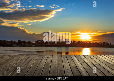 Vide jetée en bois au coucher du soleil un beau matin coloré. Banque D'Images