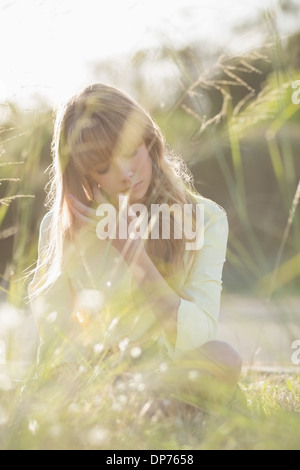 Hipster blonde girl sitting on the grass Banque D'Images