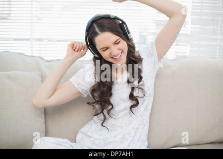 Cheerful young woman dancing tout en écoutant de la musique Banque D'Images
