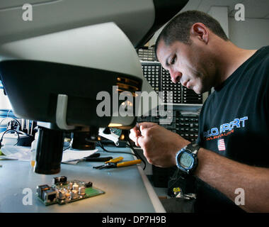 Aug 31, 2006 ; Rancho Bernardo, CA, USA ; technicien senior Engineering Corp. Sensoria DAVID BOYETT rassemble un petit circuit imprimé à l'aide d'un microscope à l'aide de la soudure de petites pièces. Sensoria Corp. fait de réseaux sans fil qui sont utilisés non seulement par les militaires, mais aussi par les universités et les municipalités qui veulent offrir l'accès Internet haute vitesse sans fil à l'extérieur. Man Banque D'Images