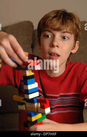 Nov 17, 2006 ; Lawrenceville, GA, USA ; les jeunes mentalement handicapés MATTHEW BENNETT, 8, avec de l'apprentissage joue avec des morceaux de LEGO pour construire tour et augmenter sa durée d'attention. Crédit obligatoire : Photo de Robin Nelson/ZUMA Press. (©) Copyright 2006 by Robin Nelson Banque D'Images