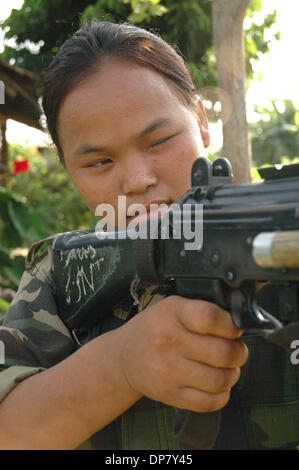 Nov 30, 2006 ; Sarlahi, Népal ; femelle de 3e brigade de chasseurs pour le Népal maoïste de l'Armée de libération du peuple de ciblage arme tout en elle fait répétition du matin dans son camp. Le Parti communiste maoïste du Népal (CPN) ont maintenant des accords de paix avec le gouvernement après 11 ans de guerre civile. Le Parti communiste du Népal a rejoint en gouvernement provisoire et déposé les armes dans le cadre de l'U Banque D'Images