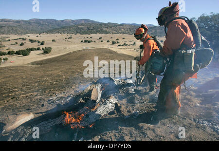 Nov 30, 2006 ; Santa Ysabel, CA, USA ; Pompiers LISA MULLINS, à gauche avec une pelle, et KELLY SOTO, plus à droite avec une tronçonneuse, travailler sur un "Smokey", encore un hot spot, près de l'origine du feu dans cette vue à la sud-est. Y'a pas de point d'origine est indiqué en descente dans la distance, la section du milieu de la photo. Crédit obligatoire : Photo par Charlie Neuman Banque D'Images