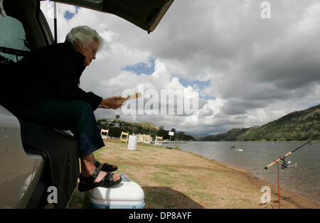 (Publié le 5/23/2006, B-1) le 22 mai 2006, Escondido, California, USA In températures plus froides que la normale pour cette période de l'année MADELEINE SMITH, de Vista, lit un livre, bien que la pêche au lac Wohlford sous les nuages de la dernière de la tempête qui traverse le comté. Elle est un régulier ici et la pêche à la barbotte Crédit obligatoire : photo par Charlie Neuman/San Diego Union-Tribune/Zuma Pre Banque D'Images