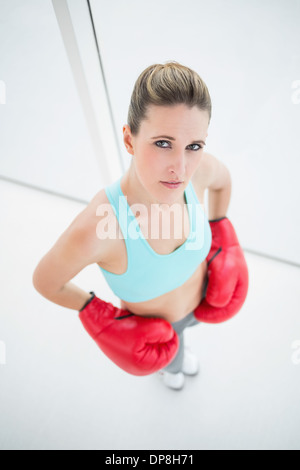 Serious woman wearing boxing gloves Banque D'Images