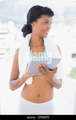 Gorgeous black haired sportswoman holding a tablet pc Banque D'Images