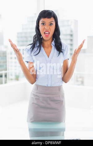 Irrité businesswoman looking at camera et raising her arms Banque D'Images