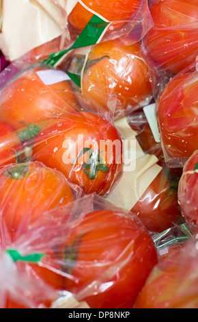 Close up de tomates fraîches emballées dans un sac en plastique transparent sur le marché. Banque D'Images