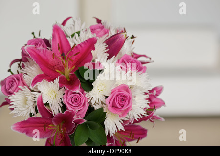 Bouquet de fleurs roses et blanches dans une chambre avec un canapé ou canapé dans l'arrière-plan Banque D'Images