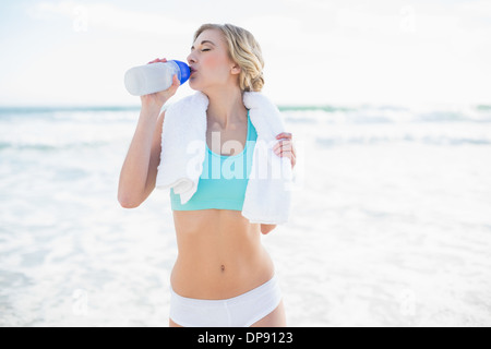 Femme blonde détendu dans l'eau potable sportswear Banque D'Images