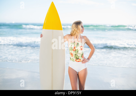Thoughtful Blonde modèle en maillot tenant une planche de surf Banque D'Images
