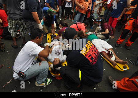 Manille, Philippines. Jan 9, 2014. Manille, Philippines - Les équipes de secours s'occuper d'une femme après qu'elle s'est effondrée comme catholiques fidèles Philippins prennent part à l'assemblée annuelle ''Traslacion'', terme espagnol pour le mouvement ou le passage, au cours de la fête de l'Église du Nazaréen noir à Manille . L'Église du Nazaréen Noir est un droit séculaire de Jésus le Christ portant sa croix et est généralement d'avis d'accomplir des miracles. ws Credit : ZUMA Press, Inc./Alamy Live News Banque D'Images