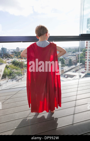 Vue arrière du petit garçon en costume de super-héros à la maison Banque D'Images