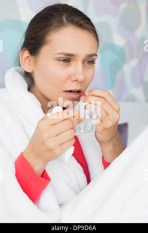 Jeune femme prenant la médecine dans la chambre à la maison Banque D'Images