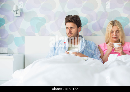 Jeune couple souffrance du froid tout en vous relaxant dans le lit à la maison Banque D'Images