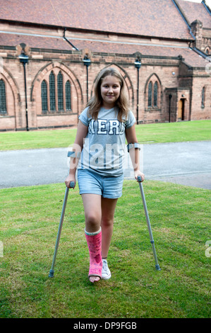 Adolescente sur béquilles jambe cassée rose Modèle en plâtre entièrement libéré Banque D'Images