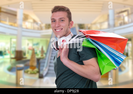 Casual Young man with shopping bags in a shopping mall Banque D'Images