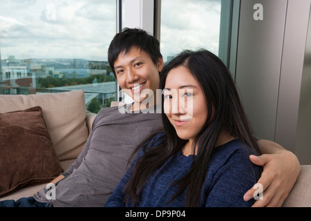 Portrait of happy friends sitting on sofa at home Banque D'Images
