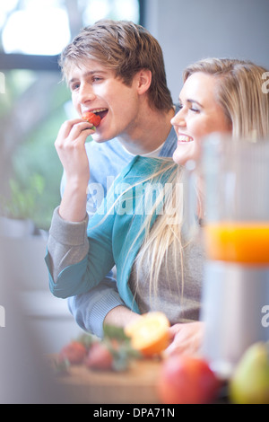 Jeune couple eating fruit et la préparation de boissons jus Banque D'Images