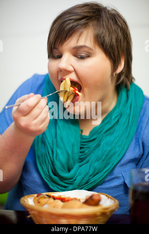 Young woman in cafe manger des frites Banque D'Images