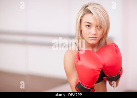 Portrait of young woman in boxing gloves Banque D'Images