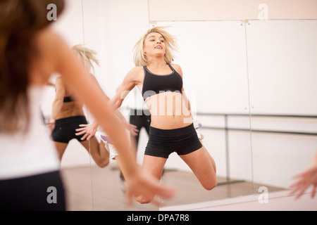 Jeune femme sautant dans d'aérobic Banque D'Images