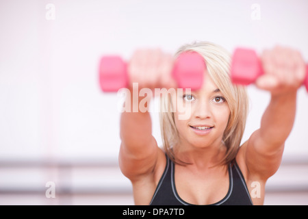 Portrait de jeune femme avec formation haltères en salle de sport Banque D'Images