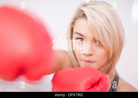 Portrait of young woman wearing boxing gloves Banque D'Images