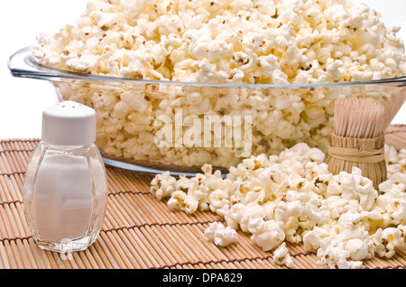 Cure-dents en bois, du sel et du popcorn sur fond blanc Banque D'Images