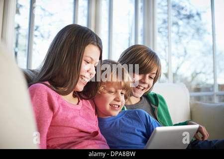 Frères et sœurs using digital tablet together