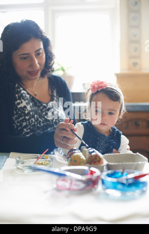 Woman and girl painting Easter eggs Banque D'Images