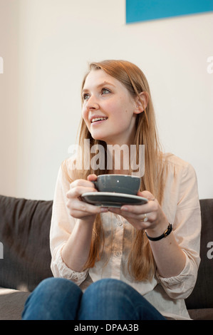 Portrait of young woman holding Coffee cup in cafe Banque D'Images