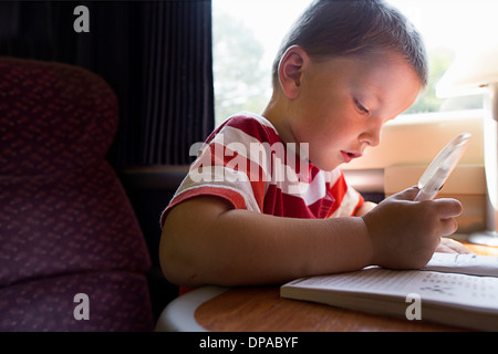 Close up of young boy avec livre-puzzle sur le train Banque D'Images