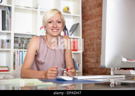 Portrait of mid adult woman at desk Banque D'Images