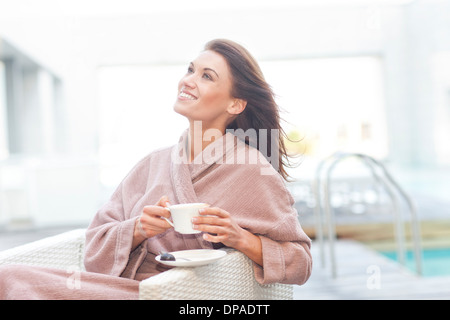 Femme à boire du café de la piscine de l'hôtel Banque D'Images