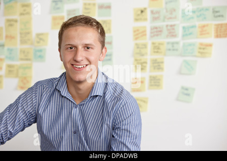 Portrait de jeune homme avec notes adhésives en arrière-plan Banque D'Images