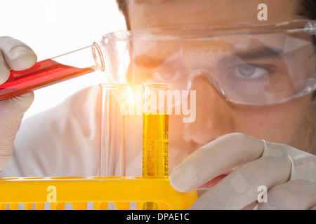 Close up of scientist pouring liquid into test tube Banque D'Images