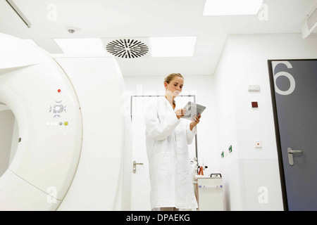 Doctor looking at digital tablet in salle de traitement Banque D'Images