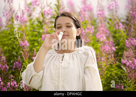 Femme en utilisant le soulagement d'allergie nasal spray Banque D'Images