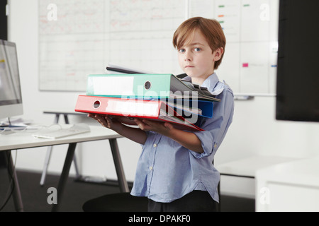 Boy holding pile de reliures Banque D'Images