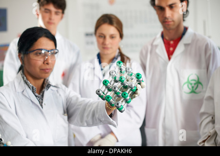 Professeur de chimie et les élèves holding molecular model Banque D'Images