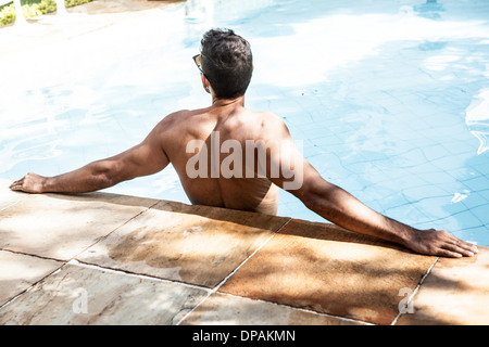 Man in swimming pool leaning with arms outstretched Banque D'Images