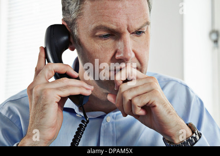 Mature businessman on téléphone fixe Banque D'Images