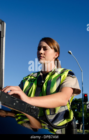 Une agente de police les types sur son ordinateur portable pendant un appel. Banque D'Images