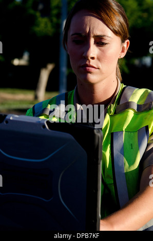 Une agente de police les types sur son ordinateur portable pendant un appel. Banque D'Images