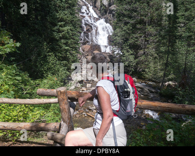 Female hiker à Hidden Falls par Jenny Lake dans le parc national de Grand Teton, Wyoming, USA Banque D'Images