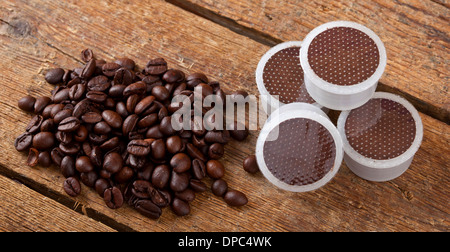 Café en grains avec pods sur table en bois. Banque D'Images