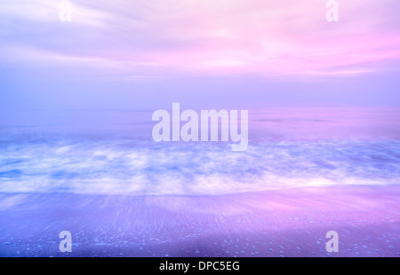 Lever de soleil rose diffusées à travers le brouillard sur la mer à embleton, Northumberland Banque D'Images