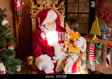 Enfant assis sur les genoux du Père Noël Banque D'Images